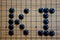 GO - abbreviation KI Lettering on the famous Asian board game GO in black