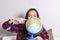 Go on an adventure. Fun woman dreaming about traveling around the world, spinning a globe and pointing at random country. Happy cu