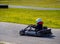 Go-cart racer with a white helmet on the circuit during daytime