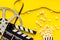 Go to the cinema with popcorn, film type and clapperboard on yellow background top view