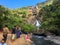 Goa, India - December 6, 2018: Beautiful view of Dudhsagar mountain waterfall. People walk near the river, admire nature and relax