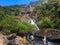 Goa, India - December 6, 2018: Beautiful view of Dudhsagar mountain waterfall. People walk near the river, admire nature and relax