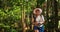 Goa, India. Young backpacker tourist woman walking and taking photos in tropical jungle forest in sunny day. lady
