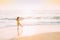 Goa, India. Young Caucasian Woman In Yellow Dress Walking Along Seashore In Summer Sunlight