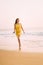 Goa, India. Young Caucasian Woman In Yellow Dress Walking On Seashore And Enjoying Life In Summer Sunlight