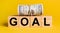 GOAL with money on a yellow background. The concept of business, finance, credit, income, savings, investments, exchange, tax