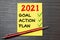 Goal,plan,action text on notepad with office accessories