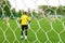 Goalkeeper back view goal post. Young team footballers play soccer background. Youth players soccer on football ground