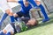 Goalkeeper with ball lies on grass in penalty area. Young teen soccer game