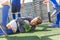 Goalkeeper with ball lies on grass in penalty area. Young teen soccer game