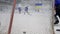 Goalkeeper in hockey suit stands at gate and catches puck from opponent at ice rink during competition, goal close-up