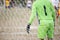 Goalkeeper stands against goal with net and stadium. Football gate net. Behind goal of soccer field