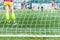 goalkeeper woman stands against goal with net and stadium. female soccer player diving to catch the ball. sporty girl