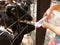 Goat farmer bottle feeds milk to a baby goat by hand