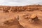 Goblin Valley - Woman hiking next to unique eroded Hoodoo Rock Formations at Goblin Valley State Park in Utah, USA, America