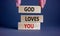 God loves you symbol. Concept words `God loves you` on wooden blocks on a beautiful grey background, prayer hand. Copy space.