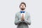 God please help me. Worried handsome bearded man in casual grey suit, blue bow tie standing with palm hands, begging god to help