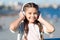 Going with the flow. Adorable headset user. Small child wearing adjustable white headset. Little girl using wireless