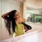 Going through her morning routine. Cropped shot of a young woman blowdrying her hair in the bathroom.