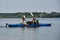 Going kayak boating with dogs on river, active pets concept, happy dog and owner on adventure. Young couple with dreadlocks having