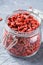 Goji berries in a jar on textured background