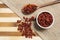 Goji Berry dry inside brown ceramic and wooden spoon on bamboo wooden background