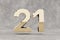 Gold 3d number 21. Glossy golden number on concrete background. 3d rendered digit