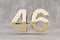 Gold 3d number 46. Glossy golden number on concrete background. 3d rendered digit