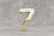 Gold 3d number 7. Glossy golden number on concrete background. 3d rendered digit