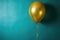 Gold balloon is hanging from side of blue wall. This image can be used to add touch of elegance