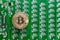 Gold bitcoin coin on the background of a green circuit board