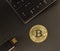 Gold bitcoin on the table next to the keyboard and USB flash drive