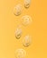 Gold bitcoins falling against orange background. Wallpaper of cryptocurrency bitcoin. Seamless pattern of bitcoin. Abstract 3D