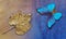 Gold and blue background. golden autumn leaf in water drops and bright blue morpho butterfly on watercolor background