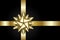 Gold bow isolated on black background. Shiny golden ribbon. Christmas satin decoration. New Year holiday design. Birthday gift.