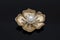 Gold brooch flower with a pearl and diamonds isolated on black