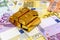 Gold bullions at euro banknotes background closeup