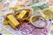 Gold bullions with handcuffs at euro banknotes background