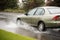 Gold car driving through puddle