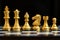 Gold chess piece stand in a row king, queen, bishop, knight, rook, pawn on black background