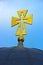 Gold Christian cross on a background of blue sky