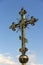 Gold Christian cross on a background of blue sky