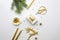 Gold Christmas flat lay. Christmas gift, scissors, gold decorations and fir branches on a white background