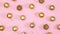 Gold Christmas ornament balls and stars appear and fill pastel pink theme. Stop motion