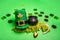 Gold coins scattered on green isolated background, St. Patricks hat, leprechaun kettle, horseshoe