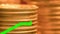 Gold coins stacked with moving green price line illustrating the rise in the price of gold