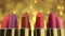 Gold color lipstick product in the shop showcase on abstract yellow background
