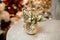 Gold colored pineapple shape vase with christmas decor composition of toys and fir-tree branches
