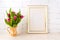Gold decorated frame mockup with pink tulips in jug
