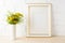 Gold decorated frame mockup yellow flowers near painted brick w